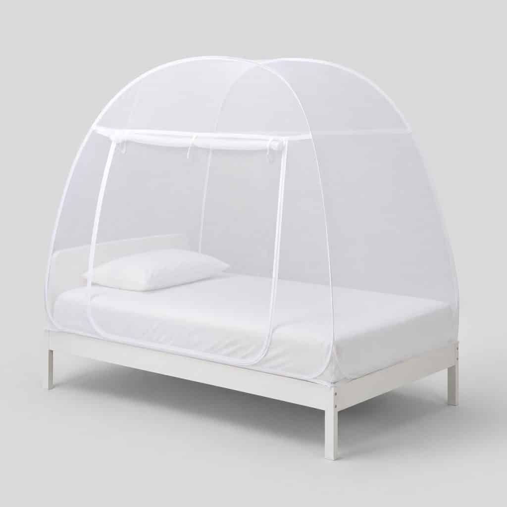 Moustiquaire dôme blanche sur un lit simple